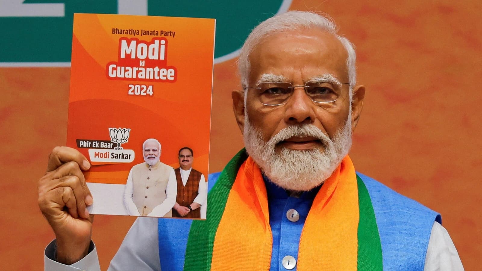 Prime Minister Narendra Modi displays a copy of the ruling Bharatiya Janata Party's (BJP) election manifesto for the general election. (Reuters)