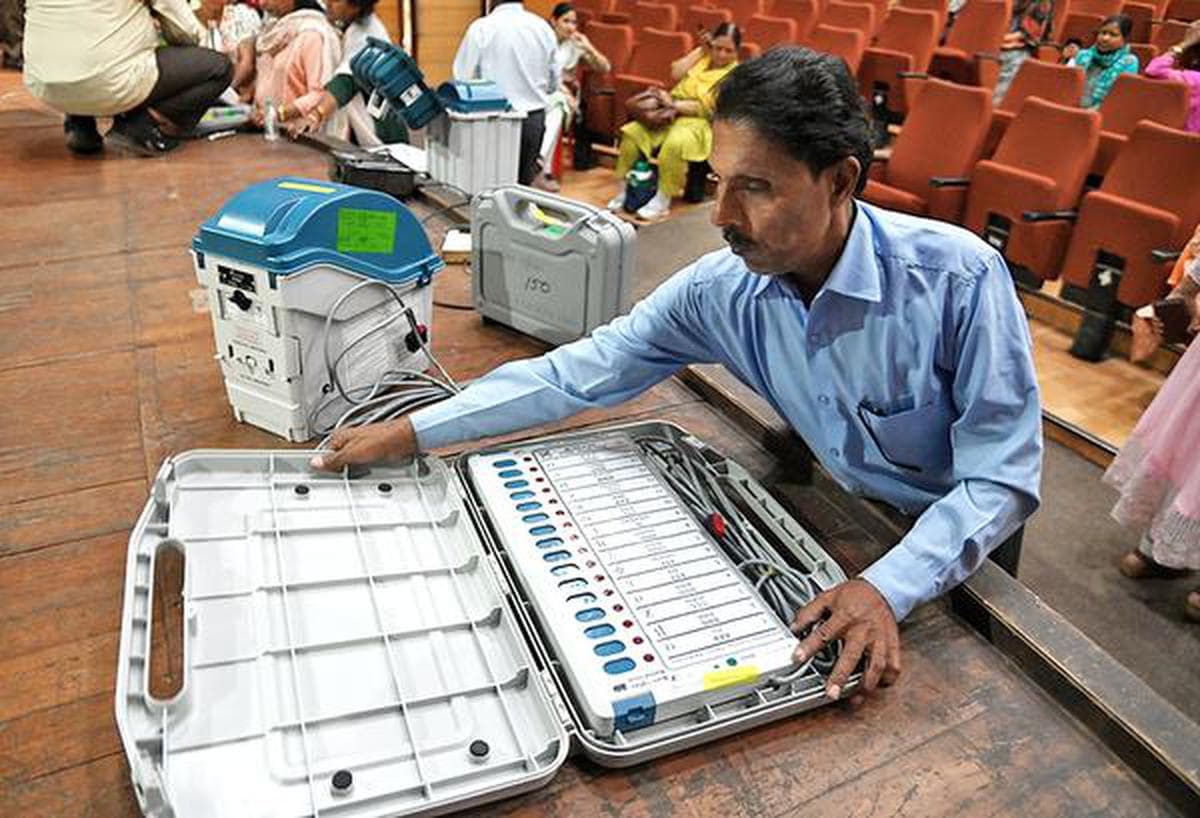 Poll officials assemble EVMs and VVPAT machines during their training