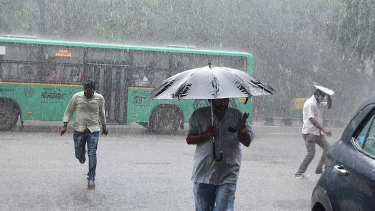 People try to take cover as heavy rain pours in Bengaluru.