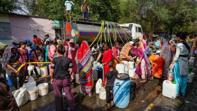 People in Delhi line up to fill water from tanker