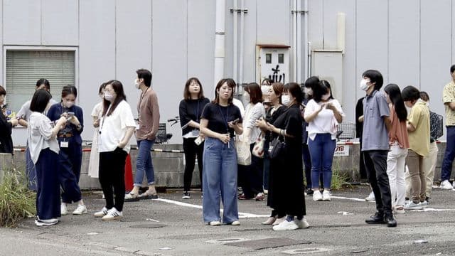 People stand outside building following an earthquake in Miyazaki, western Japan. (Image: Kyodo News via AP)