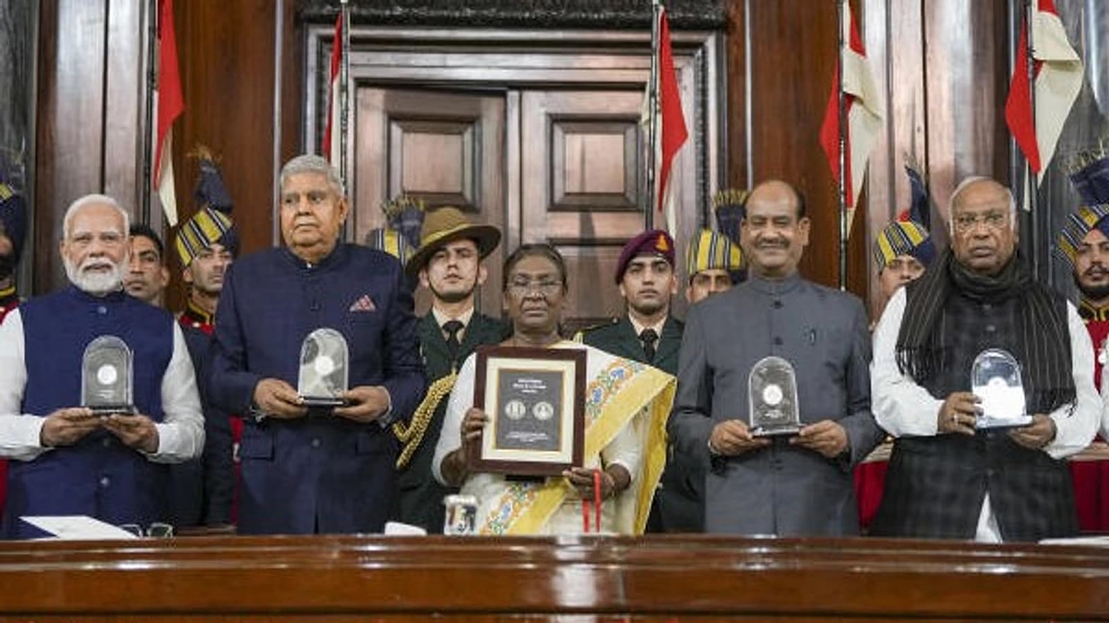 President Droupadi Murmu with Vice President Jagdeep Dhankhar, Prime Minister Narendra Modi, Lok Sabha Speaker Om Birla and LoP in the Rajya Sabha Mallikarjun Kharge releases a commemorative coin during 'Samvidhan Divas' function at Samvidhan Sadan, in New Delhi. (Credit: PTI)