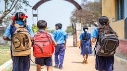 Indian schoolchildren walking on a road to reach school, highlighting RTE Act school distance and accessibility concerns.